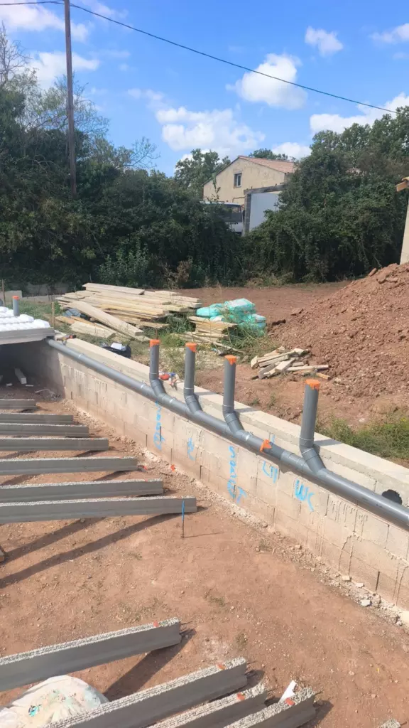 Évacuations en PVC le long d'un mur de soubassement