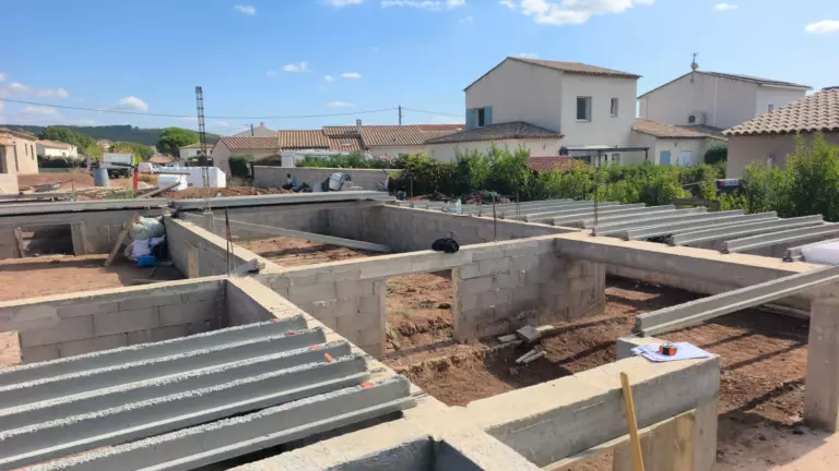 Murs de soubassement en parpaings et poutrelles posées sur le vide sanitaire