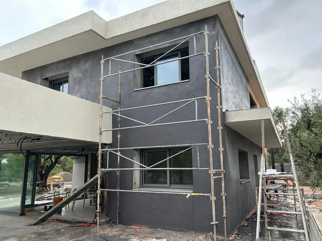 Villa en construction : enduit de façade en cours, échafaudage en place